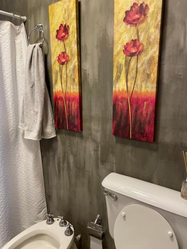 uma casa de banho com WC e duas pinturas na parede em Apartamento para 3 Personas em San Juan