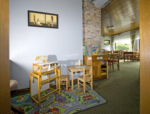 a room with a classroom with a table and chairs at Pension "Dorfkrug" in Winterberg