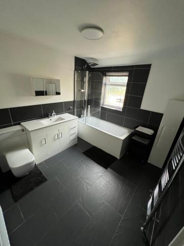 y baño con bañera, aseo y lavamanos. en Modern 2 Bed House in Rainham, Kent - Central Location en Rainham