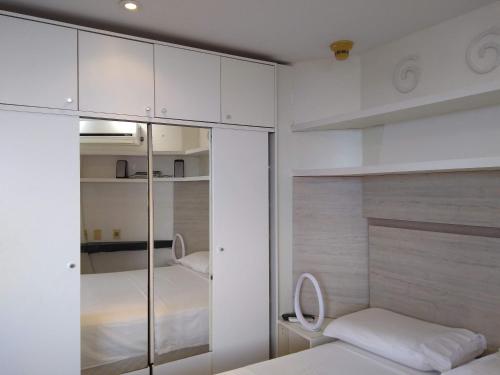 a small bedroom with white cabinets and a bed at Flat particular no Blue Tree Fortaleza in Fortaleza