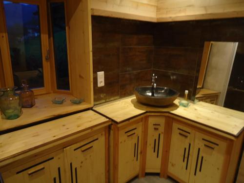 a bathroom with a sink on a wooden counter at L'Eterlou Chambres d'Hote in Albertville