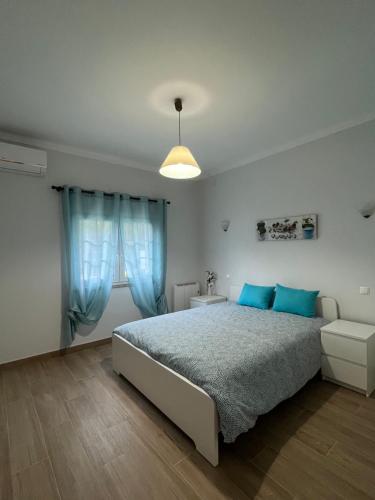 ein Schlafzimmer mit einem Bett mit blauen Kissen und einem Sofa in der Unterkunft Casa Pinto in Linhares de Cima