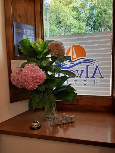 a vase of flowers sitting on a window sill at Hotel Alvaro frente Palacio-Museo Selgas in Cudillero