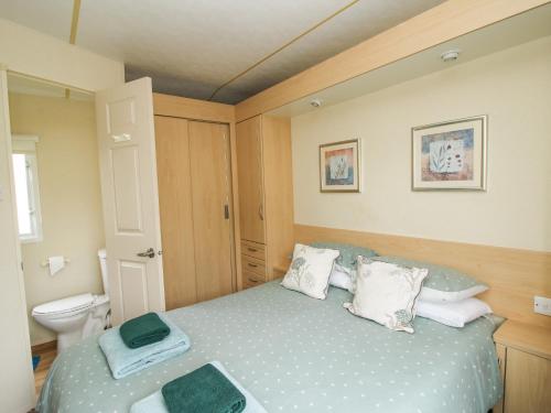 a small bedroom with a bed and a toilet at 4 Old Orchard in Much Wenlock