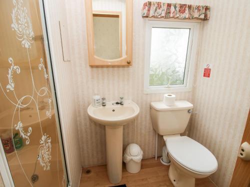 a bathroom with a toilet and a sink and a shower at 9 Old Orchard in Much Wenlock