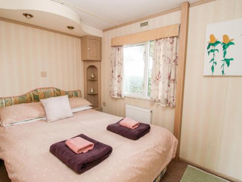 ein Schlafzimmer mit einem Bett mit zwei Handtüchern darauf in der Unterkunft 7 Old Orchard in Much Wenlock