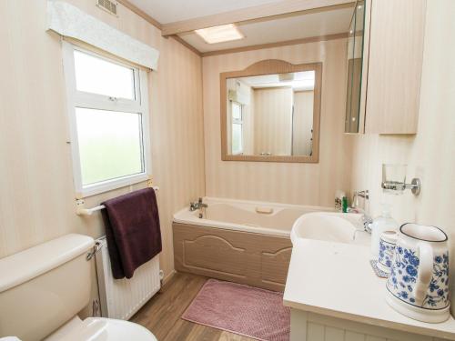 ein Badezimmer mit einem Waschbecken, einer Badewanne und einem WC in der Unterkunft 7 Old Orchard in Much Wenlock