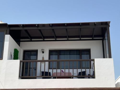 a house with a balcony with chairs on it at Casa La Orilla 2 in Playa Honda