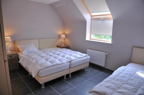 a bedroom with two beds and a window at Petit coin de paradis in Somme-Leuze