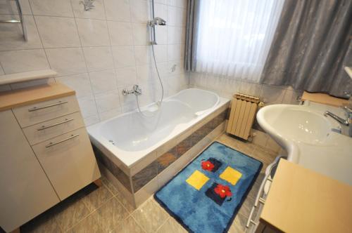 a bathroom with a tub and a sink at Landhaus Glockner in Bruck an der Großglocknerstraße