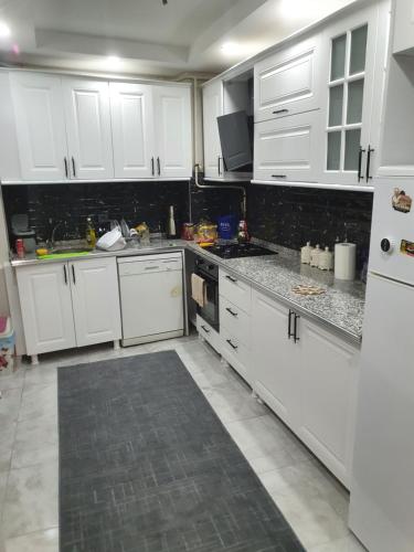 una cocina con armarios blancos y electrodomésticos blancos en Mükemmel Konumda Lüx Business Concept Daire en Sivas