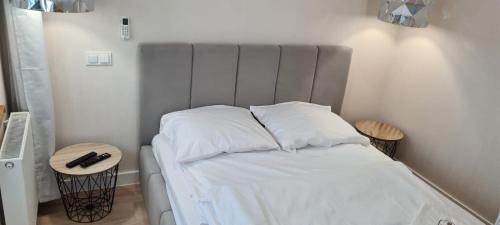 un letto con lenzuola e cuscini bianchi in una stanza di Neu Schweizerhaus 29 a Karpacz