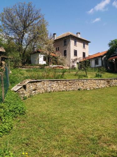 a stone retaining wall in front of a house at Guest House Pepeliana in Sŭbotkovtsi