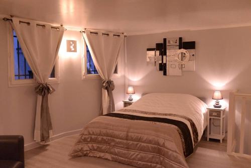 une chambre avec un lit et deux fenêtres dans l'établissement Beau studio meublé 2min du Moulin Rouge, à Paris