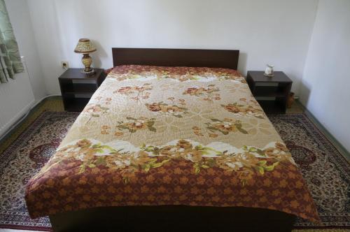a bedroom with a bed with a comforter on it at Guest House Pepeliana in Sŭbotkovtsi