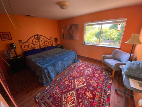 1 dormitorio con cama, ventana y alfombra en My Big Art Project, en Santa Rosa
