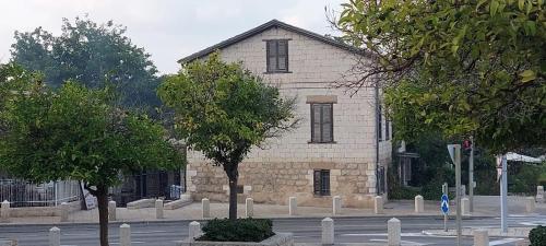 an old stone church with trees in front of it at Attic Ben Gurion 42 in Haifa