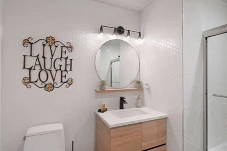 Baño blanco con lavabo y espejo en Flats-King bd-Corner Unit en Newark