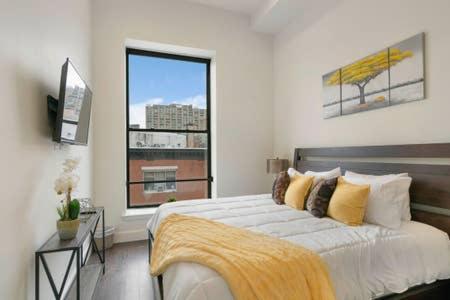 a bedroom with a large bed and a window at Flats-King bd-Corner Unit in Newark