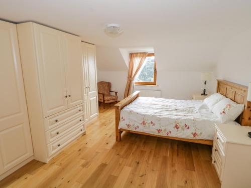 Meenataggart的住宿－Blue Stack House，一间卧室配有一张床,铺有木地板