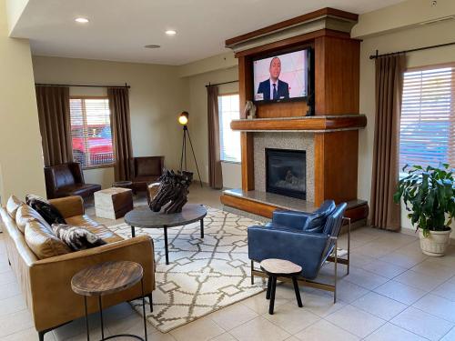a living room with a tv above a fireplace at Best Western PLUS Peppertree Inn at Omak in Omak
