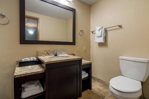 y baño con aseo, lavabo y espejo. en Best Western Plus Kamloops Hotel, en Kamloops