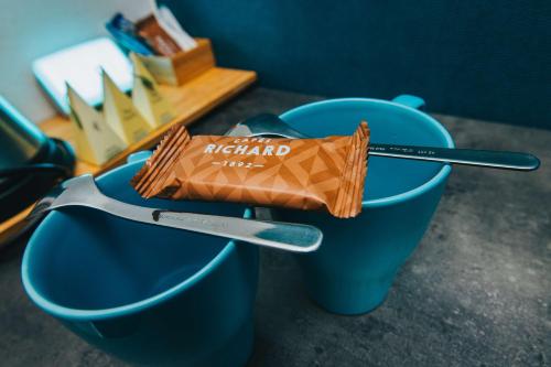 a packet of chocolate in a blue bowl with a fork at Best Western ARThotel in Le Havre