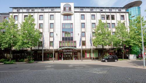 ein großes Gebäude mit einem davor geparkt in der Unterkunft Dorint Hotel Leipzig in Leipzig