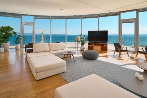 uma sala de estar com um sofá branco e uma televisão em Radisson Blu Resort & Spa em Split