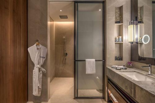 a bathroom with a glass shower and a sink at Radisson Blu Hotel & Spa, Nashik in Nashik