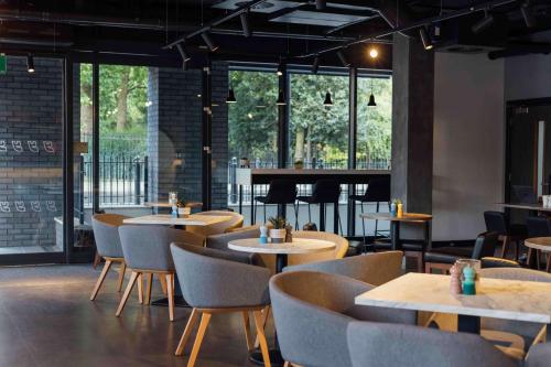 a restaurant with tables and chairs and a piano at YOTEL London Shoreditch in London