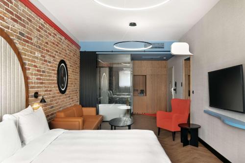 um quarto de hotel com uma cama e uma televisão em Radisson RED Gdansk, Wyspa Spichrzów em Gdansk