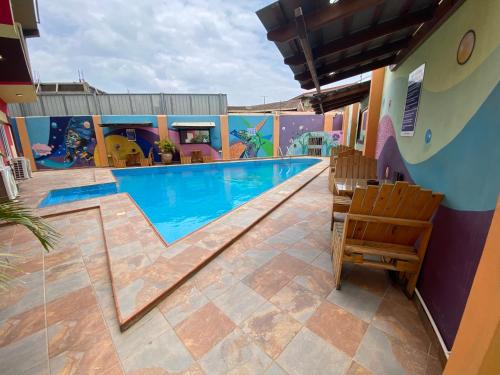 a swimming pool with two chairs next to a building at Bays Lodge, Accra in Accra