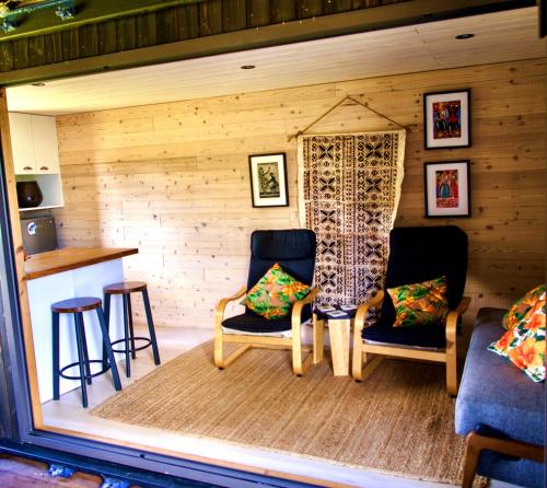 a living room with two chairs and a window at 'ARE PEPE one bedroom container style unit in Rarotonga