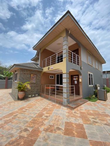 a house with a large patio in front of it at Bays Lodge, Accra in Accra