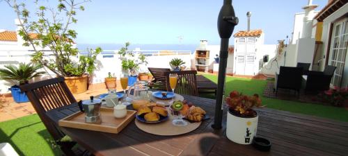 a wooden table with a plate of food on a patio at Ático El Marquito in Santa Cruz de la Palma
