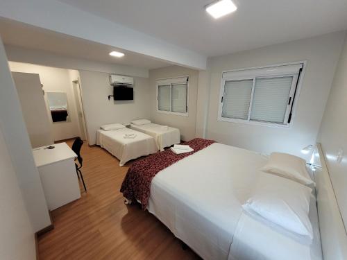 a hotel room with two beds and a window at Pousada dos Frades in Garibaldi