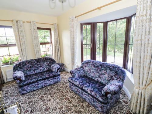 a living room with a couch and a chair at Belladrihid Cottage in Ballysadare