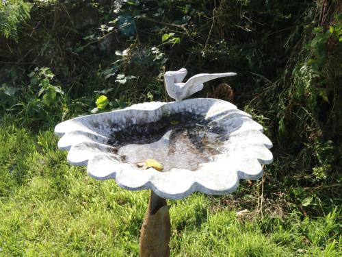 a bird sitting on top of a flower statue at Belladrihid Cottage in Ballysadare