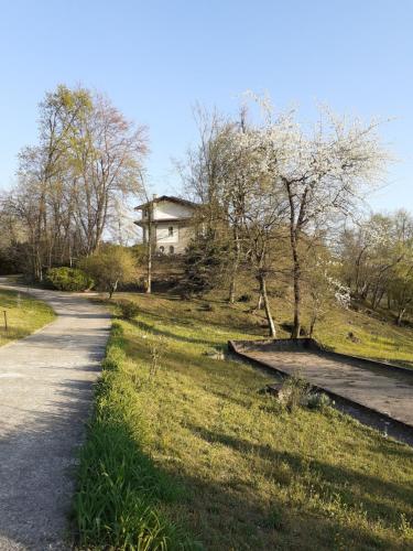 un chemin de terre à côté d'un champ avec une maison dans l'établissement Al Picchio Verde A.P.S., à Cunardo