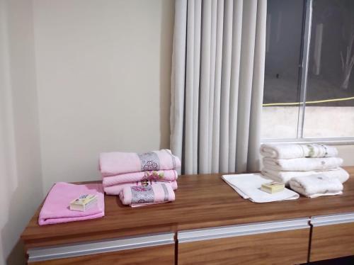 a pile of towels sitting on top of a wooden counter at CASA DE CAMPO Banheira, Lareira e Cachoeira in Pedra Azul