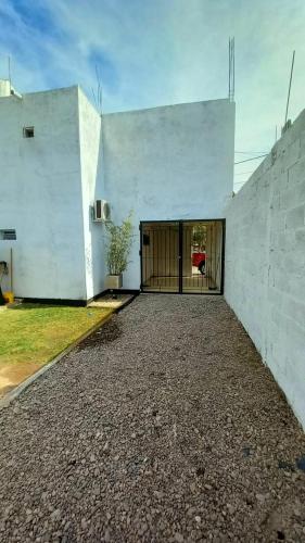 a white building with a door and a courtyard at monoambiente huellas2 in La Rioja