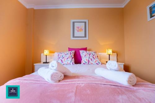 1 dormitorio rosa con 1 cama rosada grande y 2 lámparas en Inma Apartment Montaña La Data en San Bartolomé
