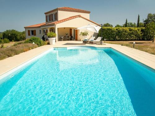 une grande piscine bleue devant une maison dans l'établissement Les Graves, à Saint-Pierre-Lafeuille