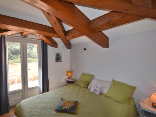 une chambre avec un lit vert et une fenêtre dans l'établissement Vue Jardin, à Sainte-Maxime