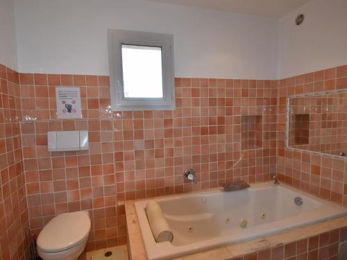 une salle de bain avec baignoire et toilettes et une fenêtre dans l'établissement Vue Jardin, à Sainte-Maxime
