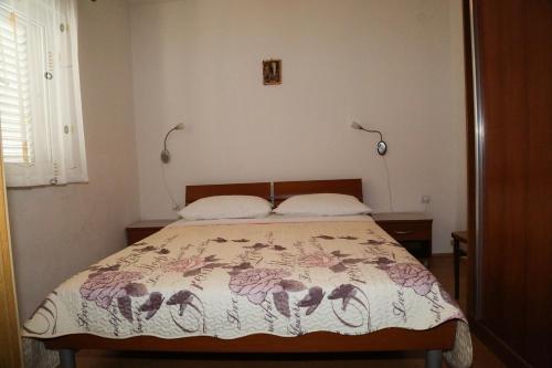 a bedroom with a bed with a floral bedspread at Apartments by the sea Milna, Hvar - 12244 in Milna