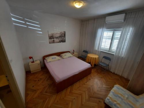 a small bedroom with a bed and a table at Apartments with a parking space Makarska - 12211 in Makarska