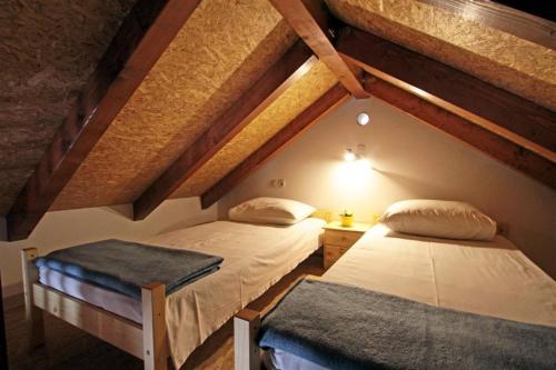 2 bedden in een zolderkamer met houten plafonds bij Seaside house with a swimming pool Vinjerac, Zadar - 9689 in Vinjerac