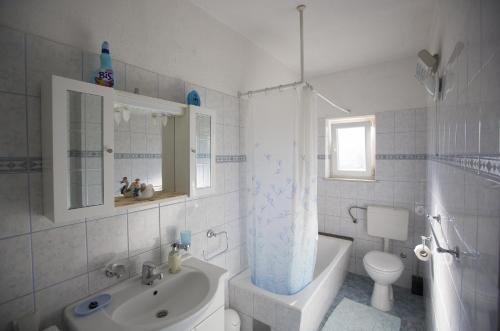 a white bathroom with a sink and a toilet at Apartments by the sea Postira, Brac - 12291 in Postira